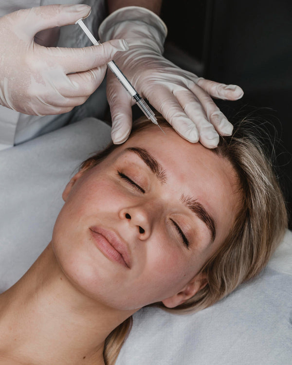 pessoa aplicando botox no rosto da uma mulher atleta